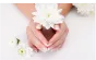 Hands holding a white flower after a manicure