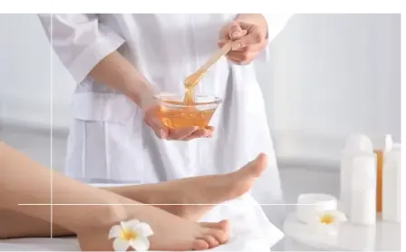 Warm honey wax in a glass bowl